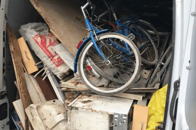 Kellerentrümpelung mit Fahrrad, Holz und Müllsäcken vor dem Abtransport